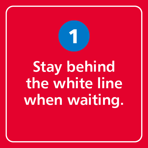 Stay behind the white line when waiting.