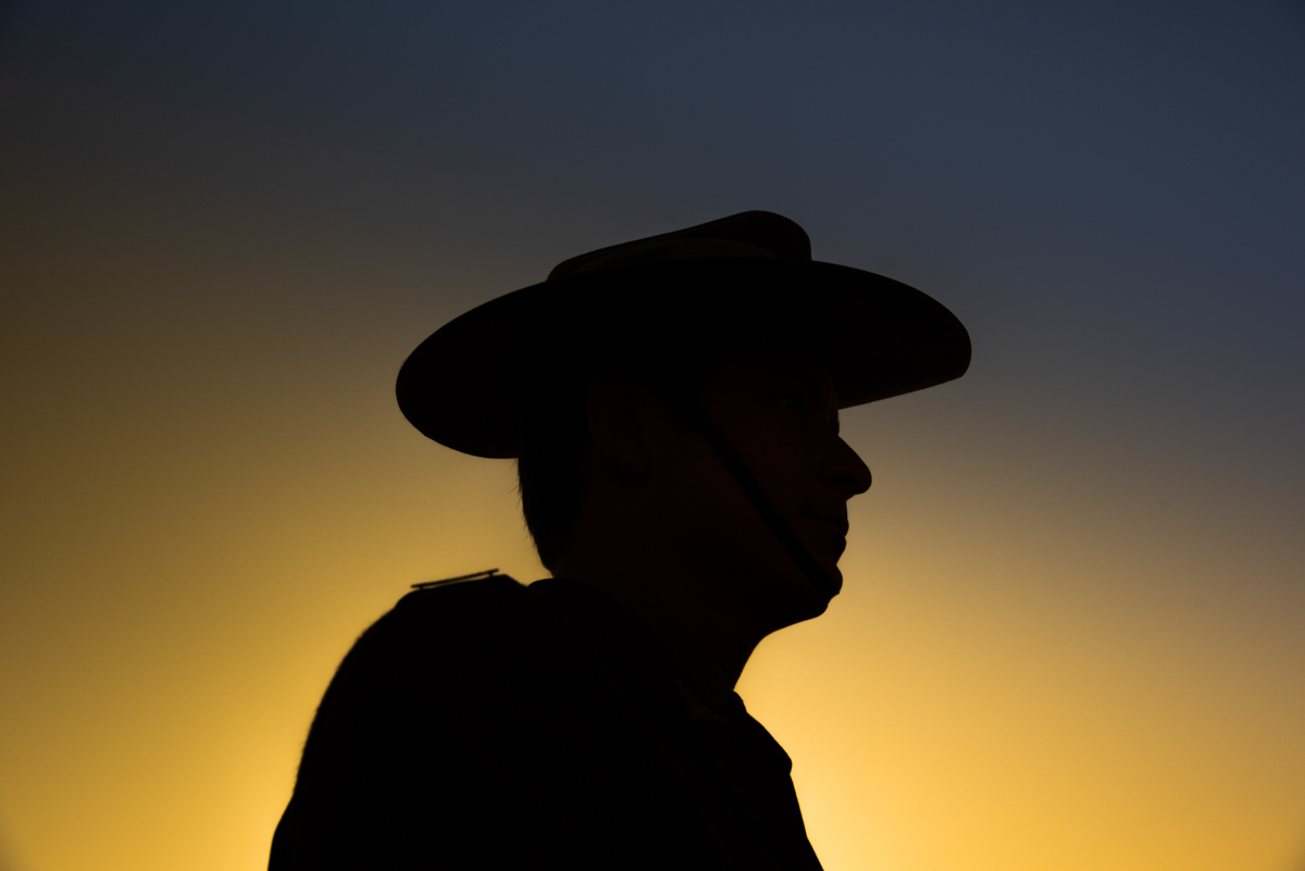 Soldier wearing hat in front of sunrise