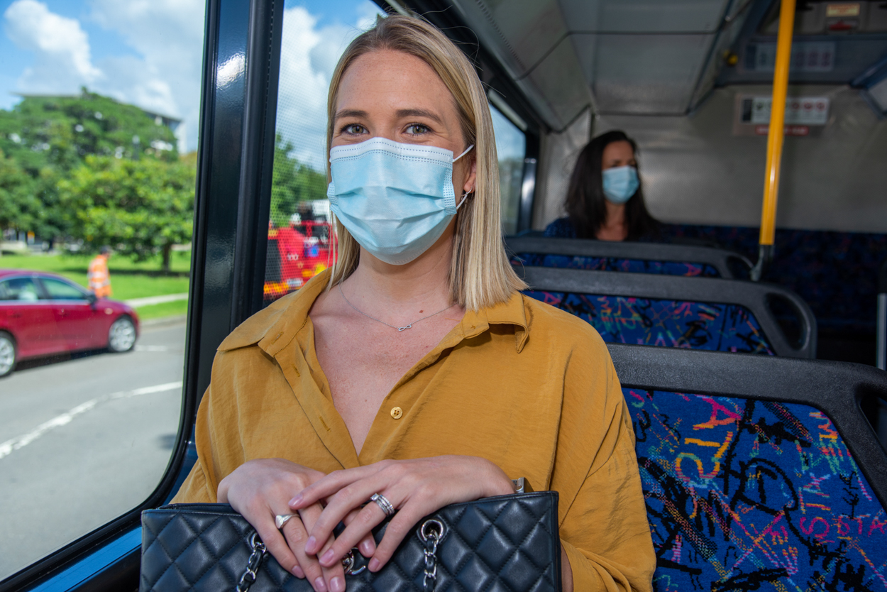 Woman sitting on a bus wearing a face mask