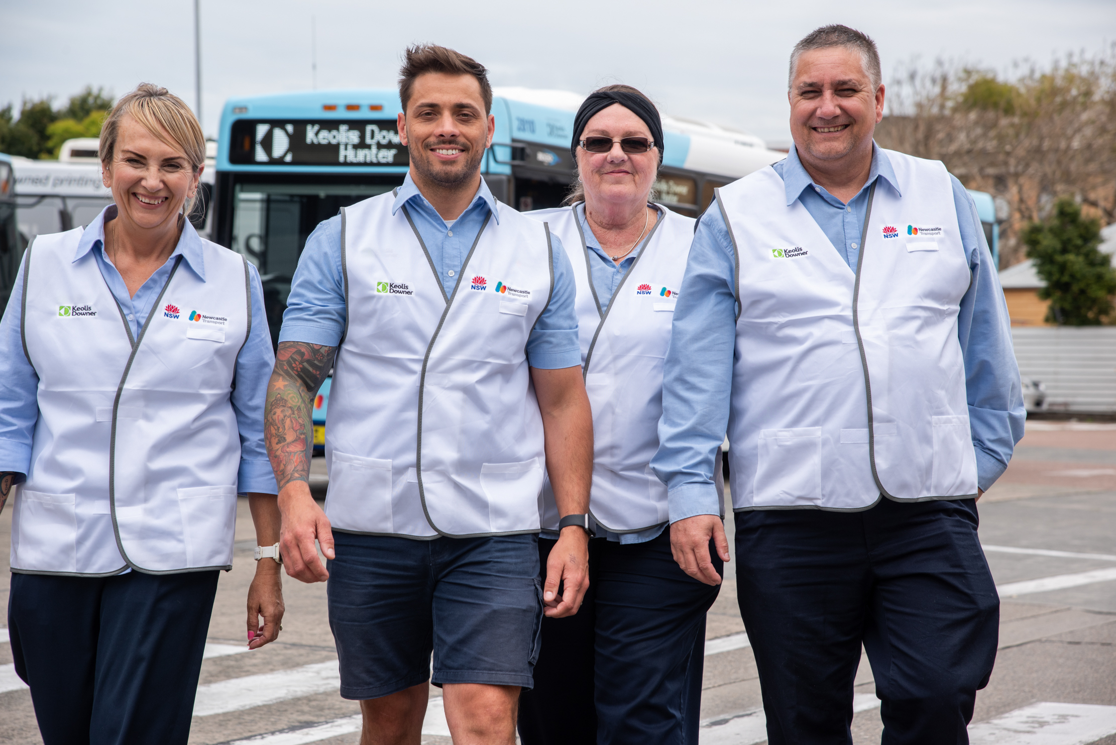 four newcastle transport authorised officers walking in front of a bus